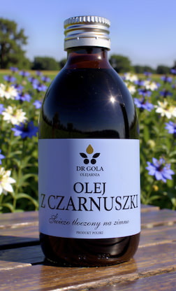 Butelka oleju z czarnuszki na tle pola czarnuszki siewnej