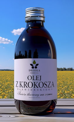 Butelka oleju z krokosza barwierskiego na tle pola uprawnego krokosza